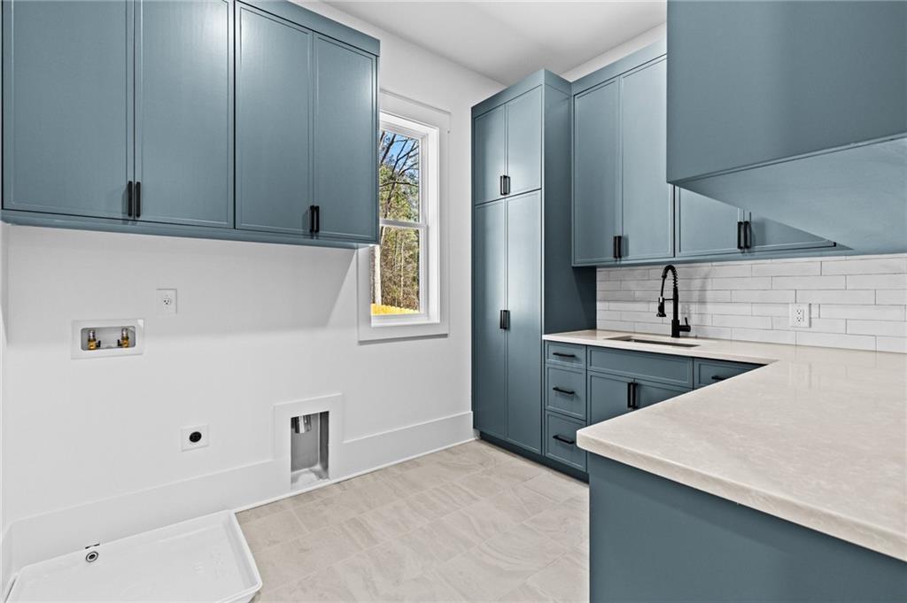 6996 Deaton Henry Road Hoschton, GA 30548 - Photo 42 of 65 a kitchen with a sink a stove and cabinets