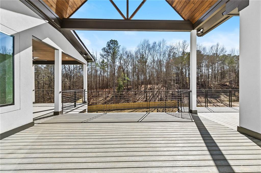 6996 Deaton Henry Road Hoschton, GA 30548 - Photo 50 of 65 a view of a balcony with floor to ceiling windows with wooden floor