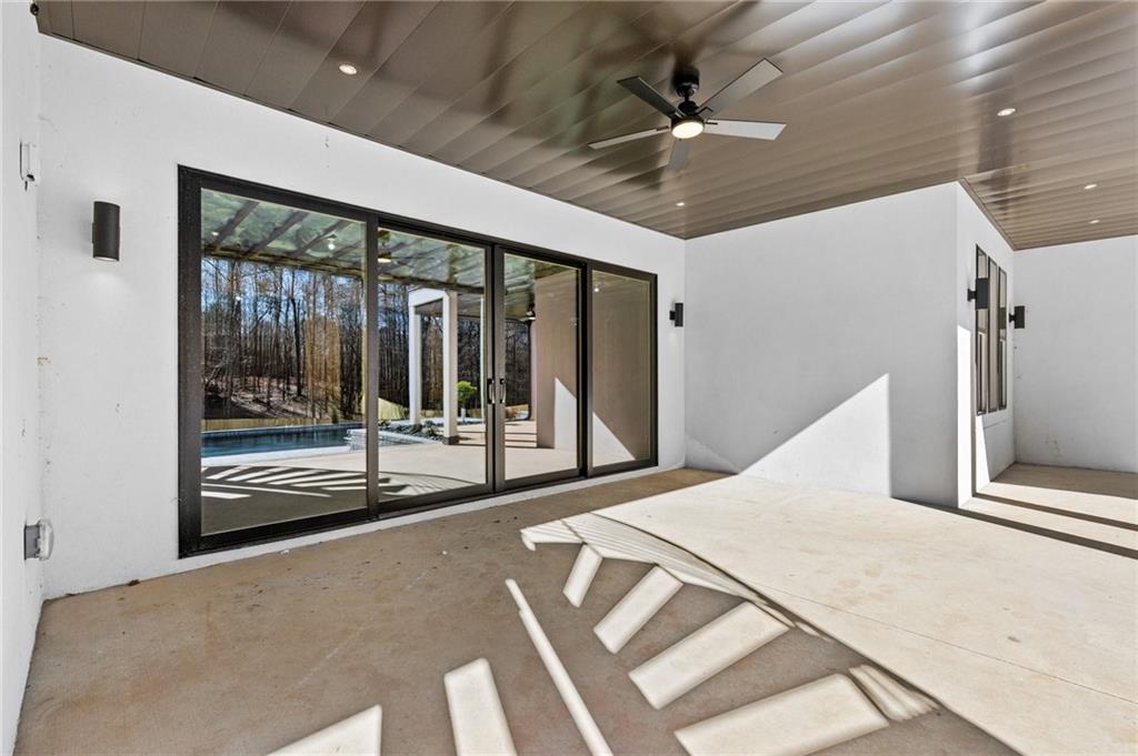 6996 Deaton Henry Road Hoschton, GA 30548 - Photo 56 of 65 a large bedroom with a large bed and a large window with balcony view