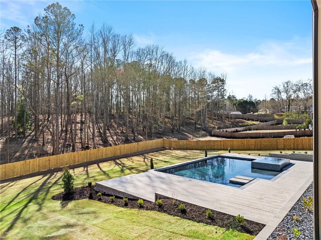 6996 Deaton Henry Road Hoschton, GA 30548 - Photo 60 of 65 a view of swimming pool with seating area and trees in the background
