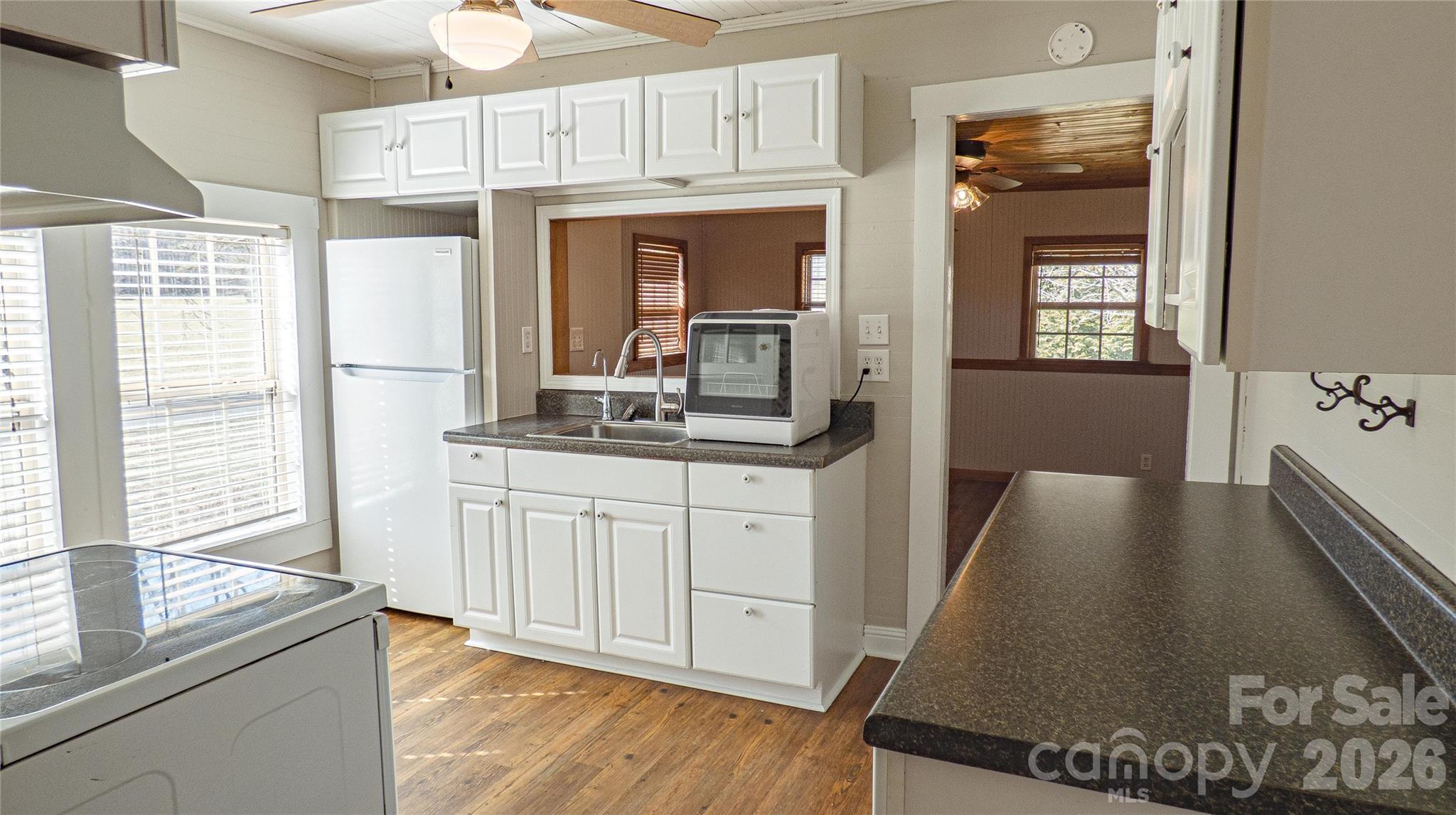 3920 St Peters Church Road Salisbury, NC 28146 - Photo 7 of 32 a kitchen with stainless steel appliances granite countertop a refrigerator a stove and white cabinets with wooden floor