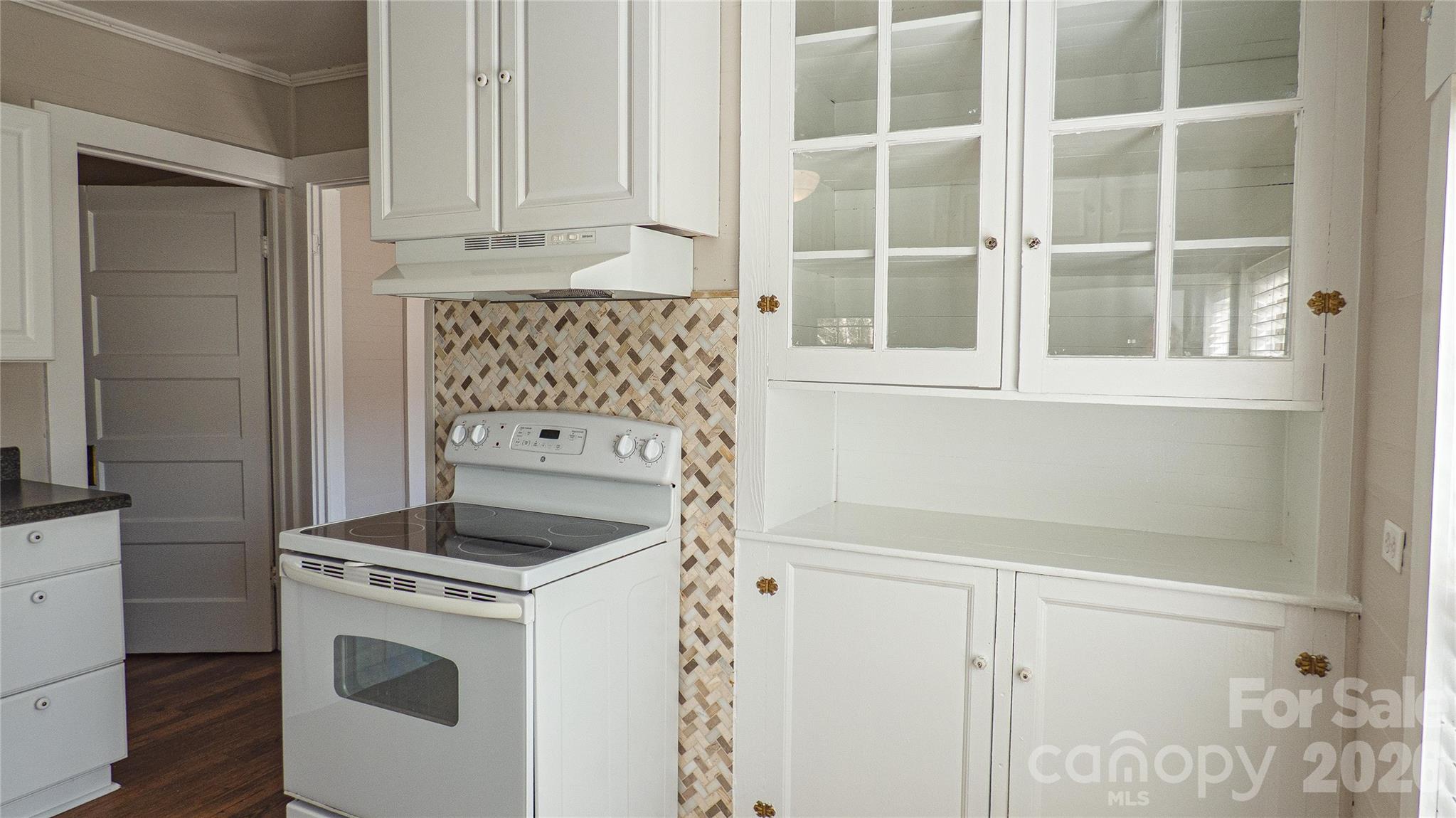 3920 St Peters Church Road Salisbury, NC 28146 - Photo 8 of 32 a kitchen with white cabinets and a stove top oven