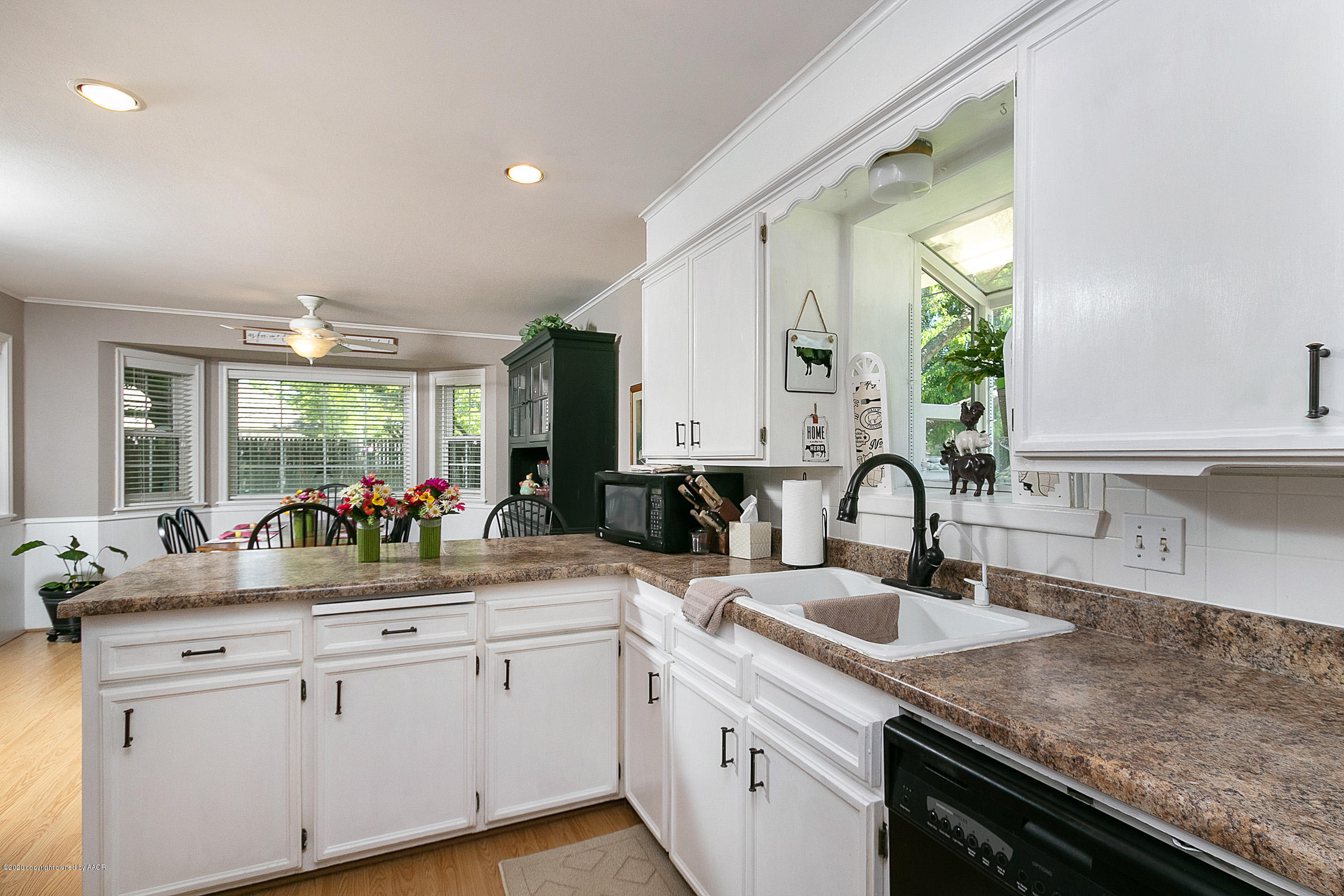 6700 Dreyfuss Road Amarillo, TX 79106 - Photo 14 of 37 a kitchen with white cabinets and a sink