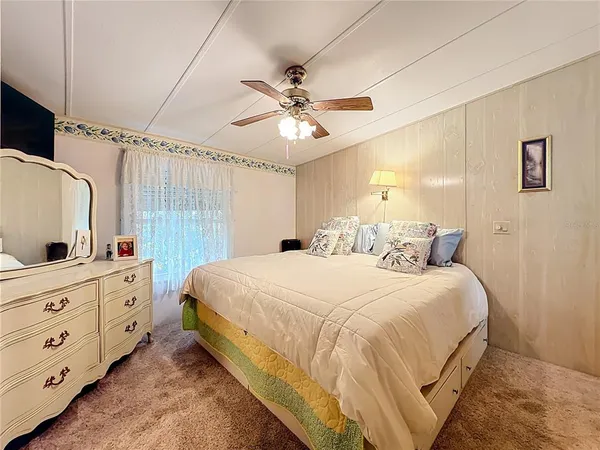 a bedroom with a large bed and a flat tv screen on a dresser