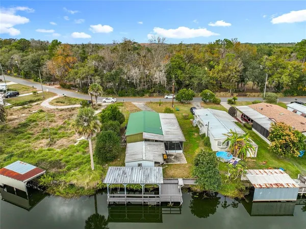 an aerial view of residential houses with outdoor space and ocean view