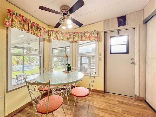 a kitchen with stainless steel appliances kitchen island granite countertop a table chairs sink and cabinets