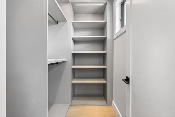 a view of walk in closet with empty racks