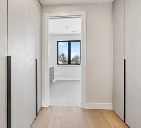 a view of a small space with wooden floor and a window