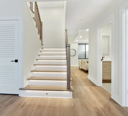 a view of a hallway with wooden floor and entryway