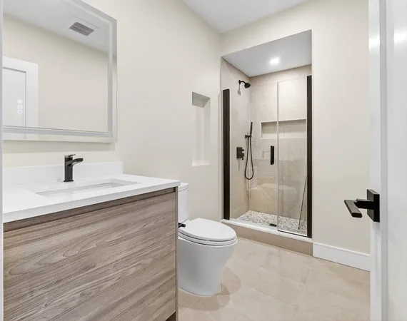 a bathroom with a sink a toilet and shower