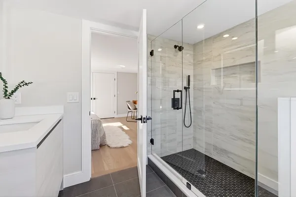 a bathroom with a granite countertop sink a toilet and shower