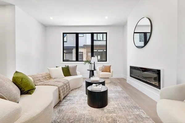 a living room with furniture a large window and a fireplace