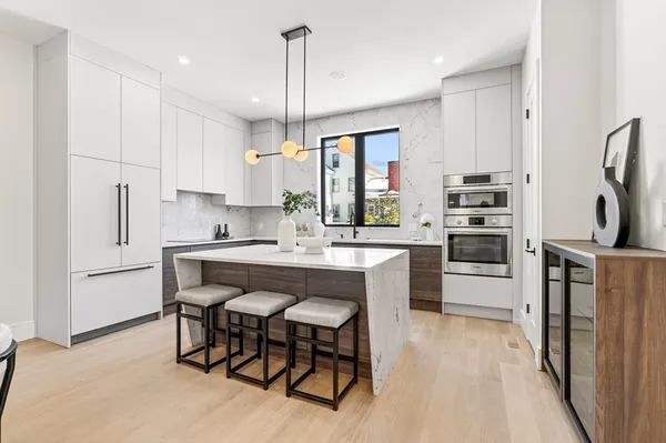 a kitchen with refrigerator a sink and chairs