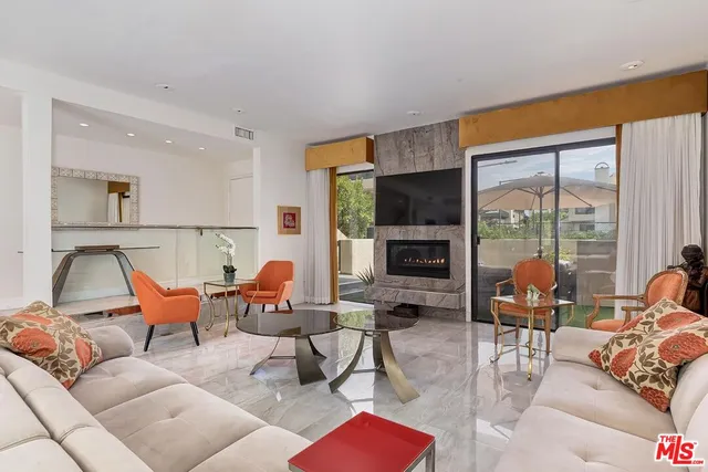 a living room with furniture kitchen view and a large window