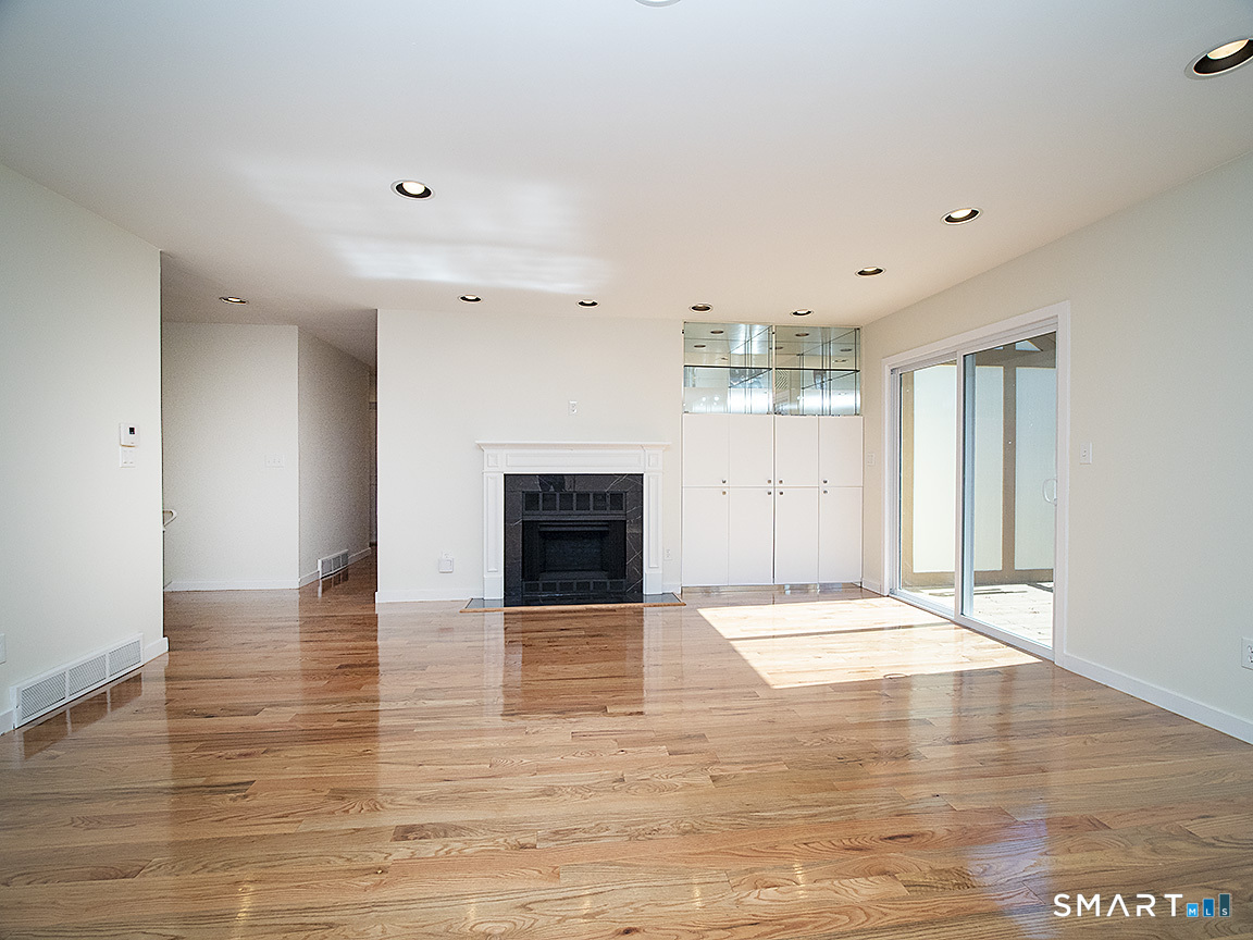 690 Forest Road, Unit 703 West Haven, CT 06516 - Photo 15 of 35 a view of an empty room with wooden floor and a fireplace