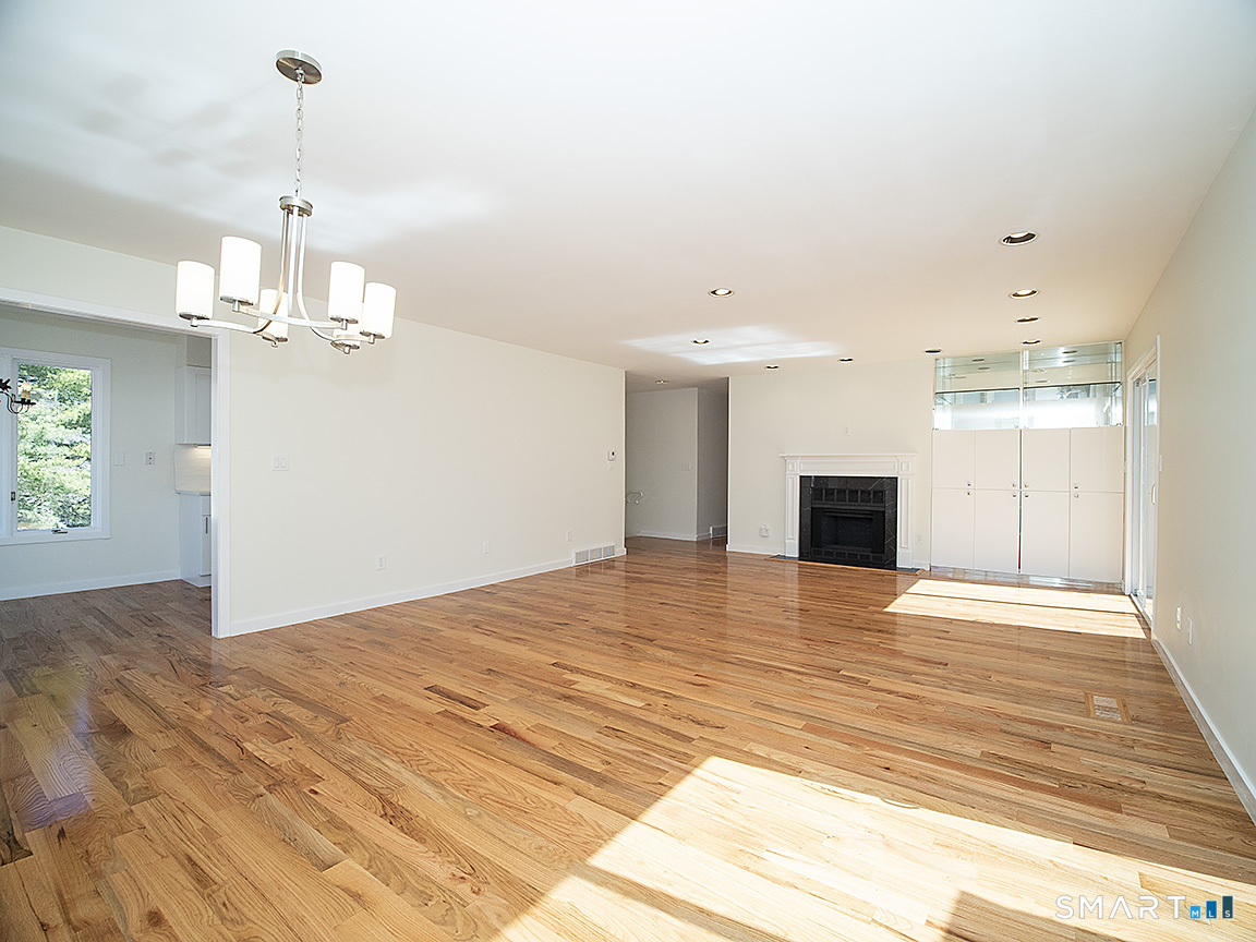690 Forest Road, Unit 703 West Haven, CT 06516 - Photo 16 of 35 a view of empty room with wooden floor and kitchen view