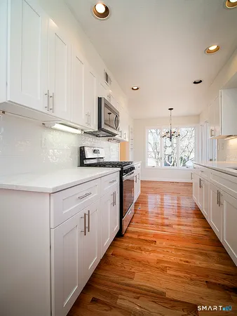 a kitchen with stainless steel appliances granite countertop a refrigerator and a stove top oven