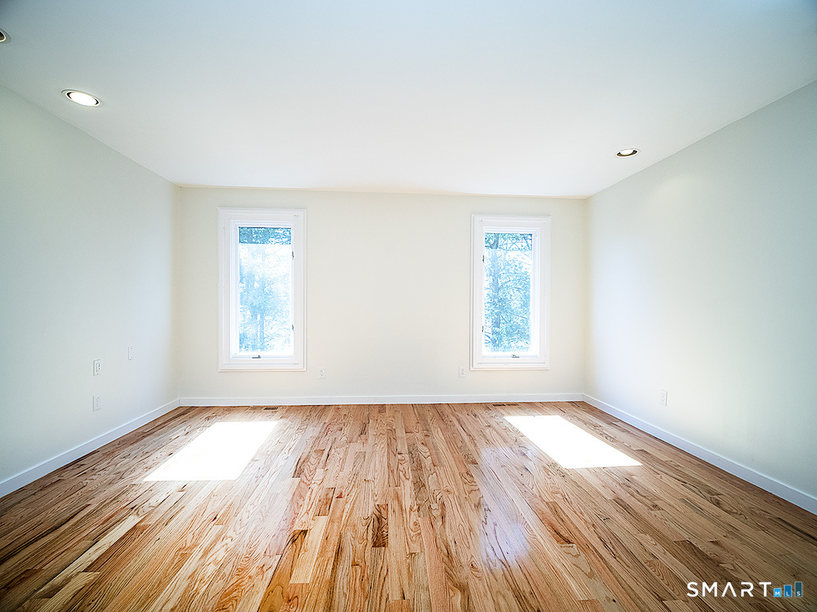 690 Forest Road, Unit 703 West Haven, CT 06516 - Photo 29 of 35 an empty room with wooden floor and windows