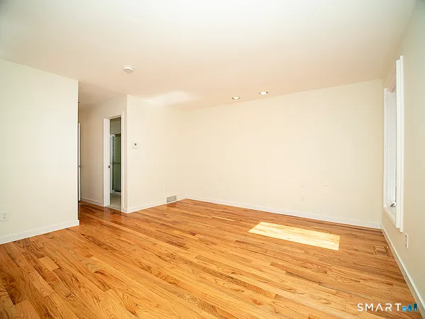 a view of empty room with wooden floor