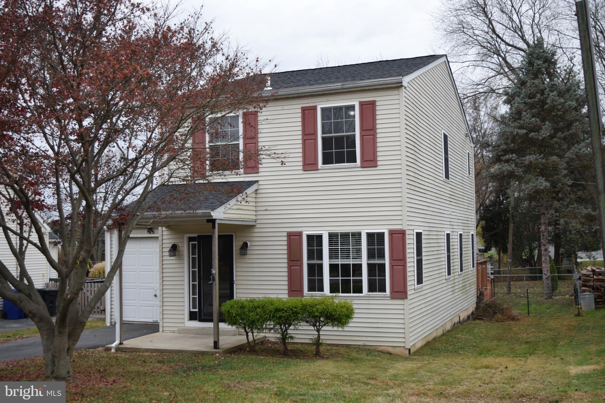 a front view of a house with a garden and trees