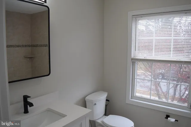 a bathroom with a toilet a sink and a window