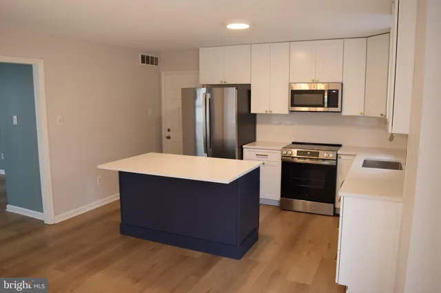 a kitchen with stainless steel appliances a refrigerator stove microwave and sink