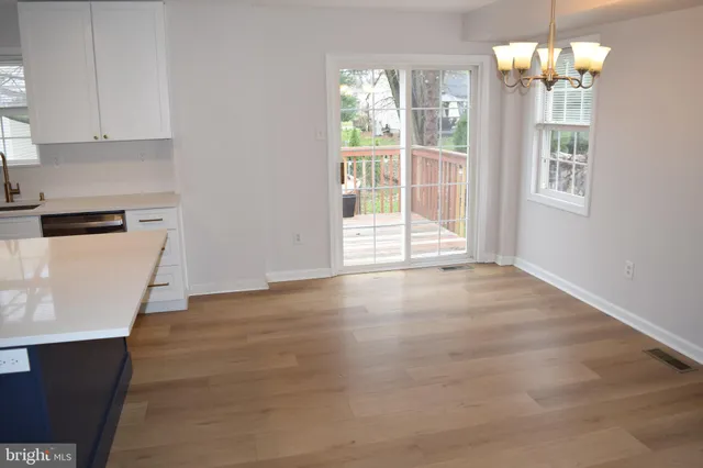 a view of a kitchen with wooden floor and stainless steel appliances