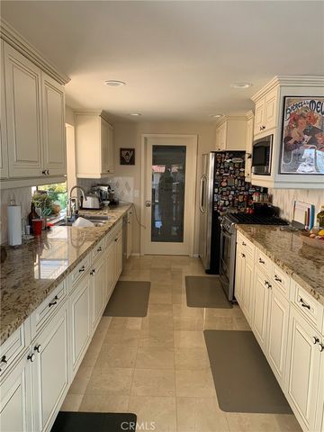 a large kitchen with stainless steel appliances kitchen island granite countertop a sink and cabinets