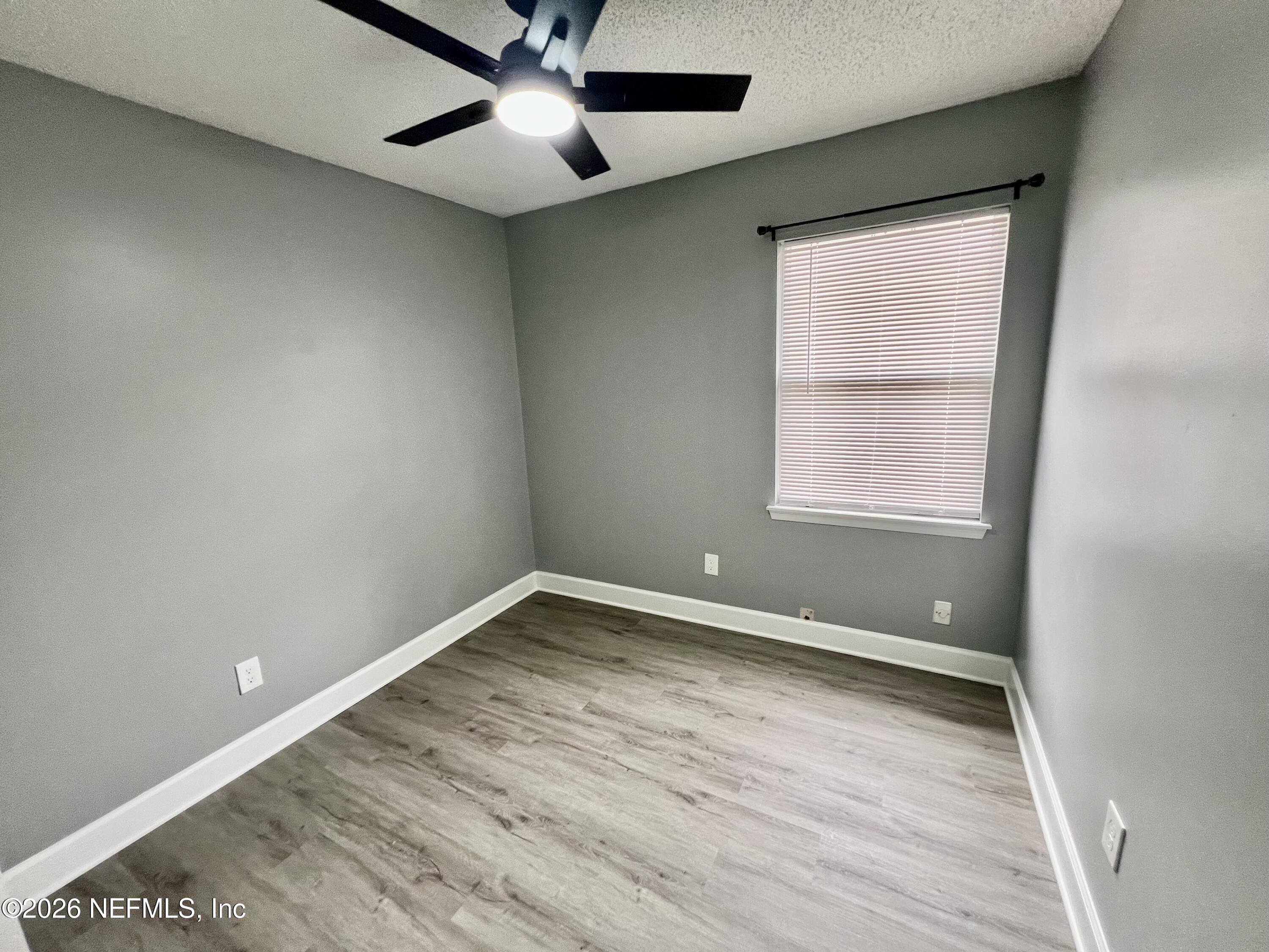 8778 Buzz Court Jacksonville, FL 32216 - Photo 13 of 22 wooden floor in an empty room with a window