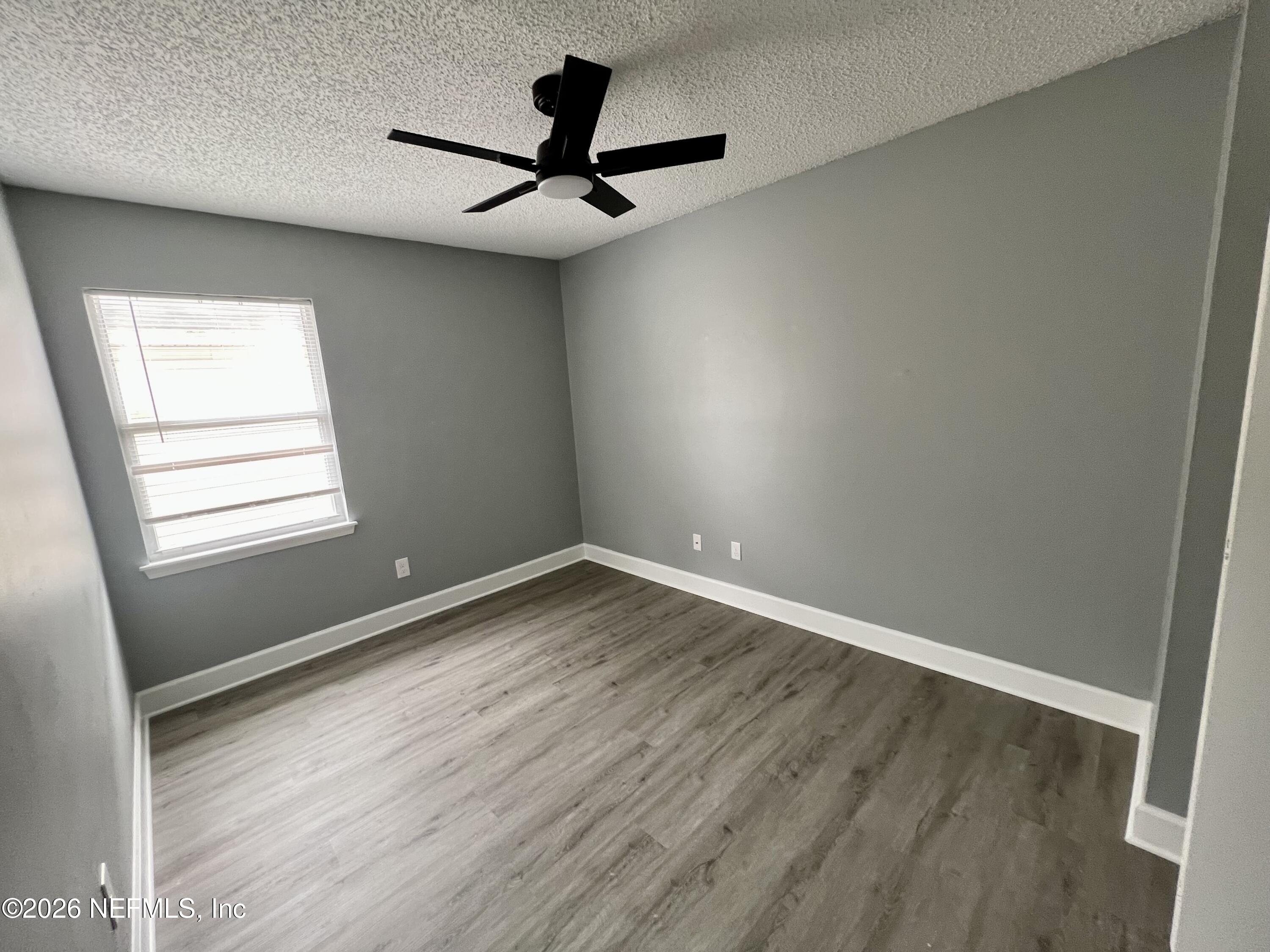 8778 Buzz Court Jacksonville, FL 32216 - Photo 15 of 22 wooden floor in an empty room with a window