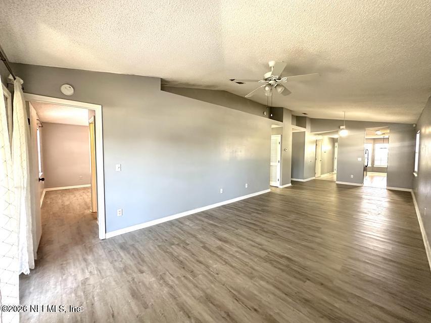 8778 Buzz Court Jacksonville, FL 32216 - Photo 6 of 22 wooden floor in an empty room with a window