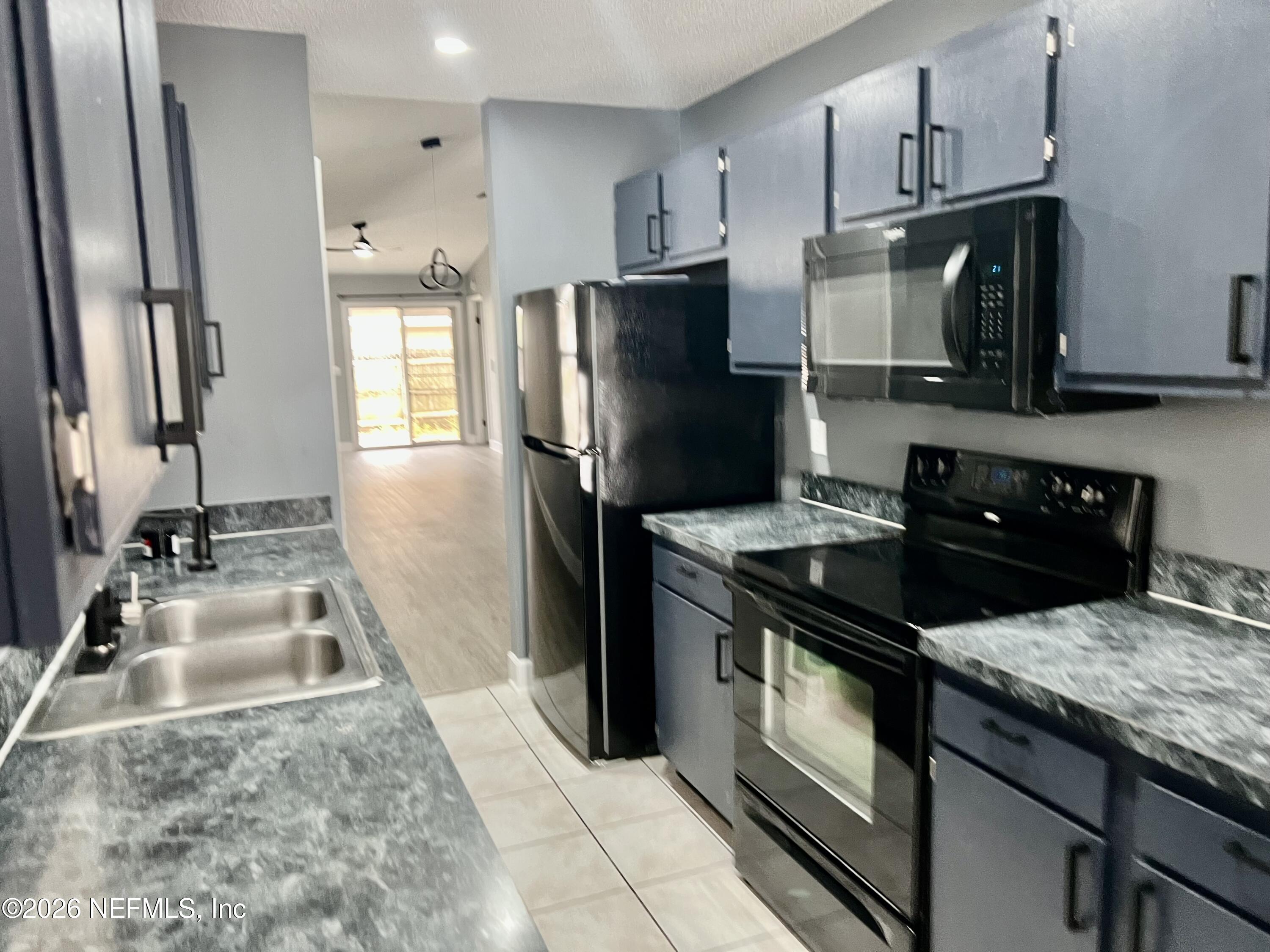8778 Buzz Court Jacksonville, FL 32216 - Photo 9 of 22 a kitchen with a sink stove and refrigerator