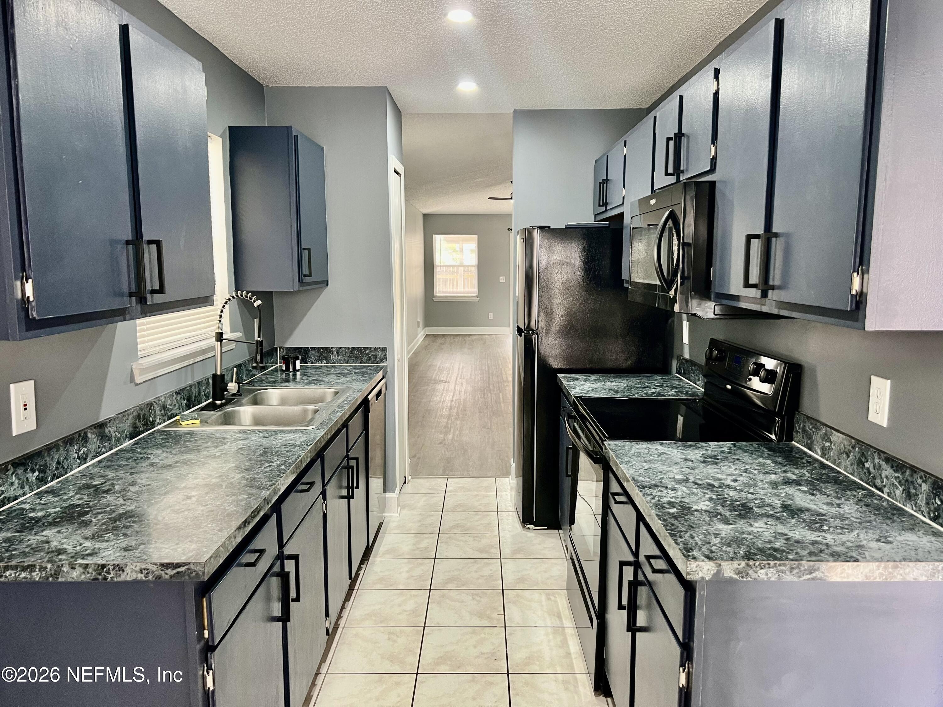 8778 Buzz Court Jacksonville, FL 32216 - Photo 10 of 22 a kitchen with stainless steel appliances granite countertop a sink stove and refrigerator