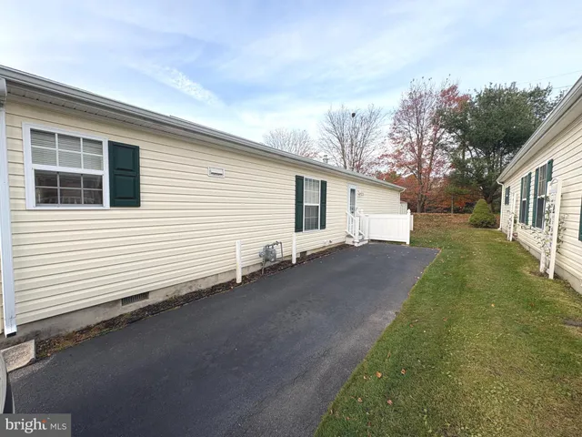 a view of a white house next to a yard