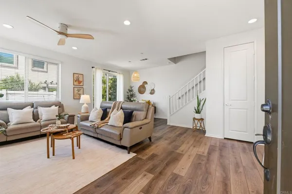a living room with furniture and a wooden floor