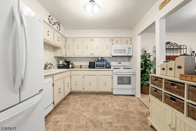a kitchen with stainless steel appliances a stove a sink and white cabinets