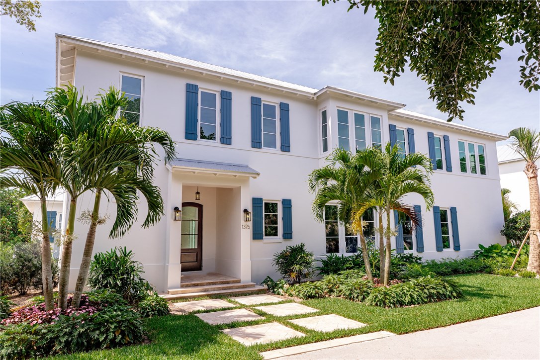 a front view of a house with yard and green space