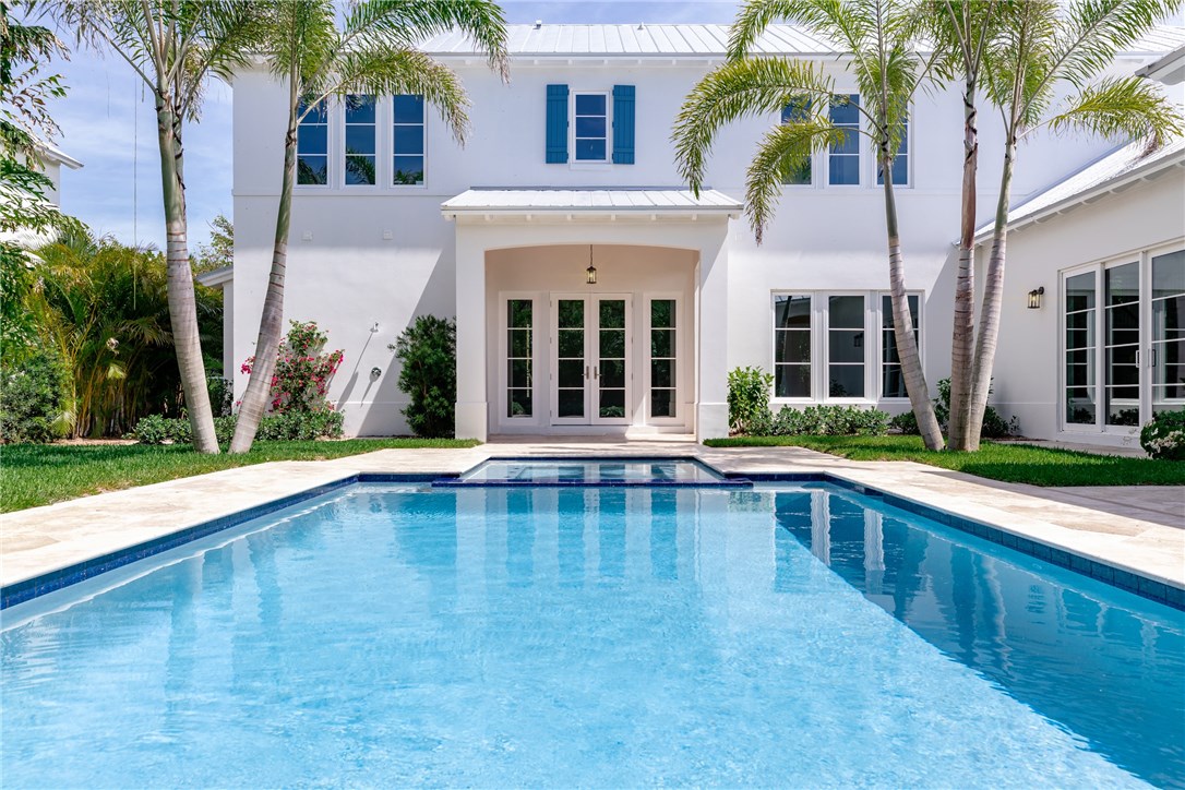 1375 Sandy Lane Vero Beach, FL 32963 - Photo 15 of 36 a view of a white building with a large pool and a large tree