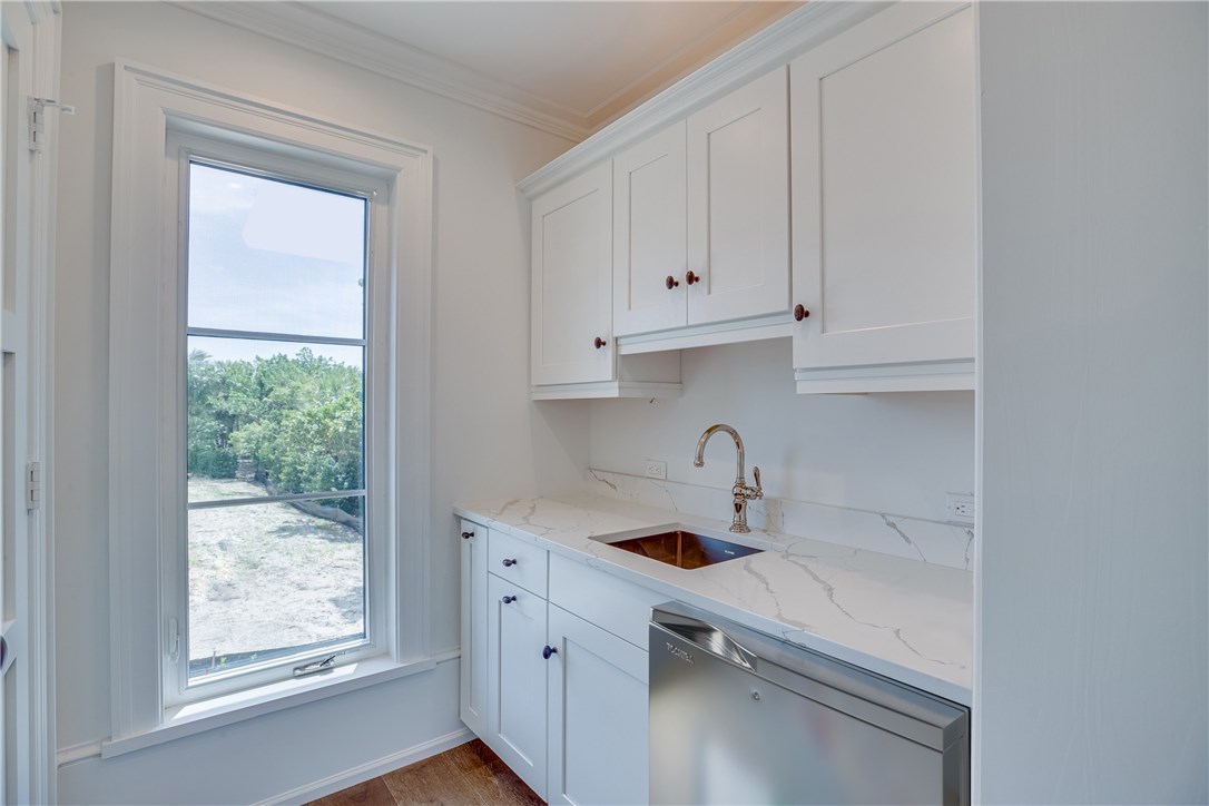 1375 Sandy Lane Vero Beach, FL 32963 - Photo 18 of 36 a kitchen with white cabinets and a window