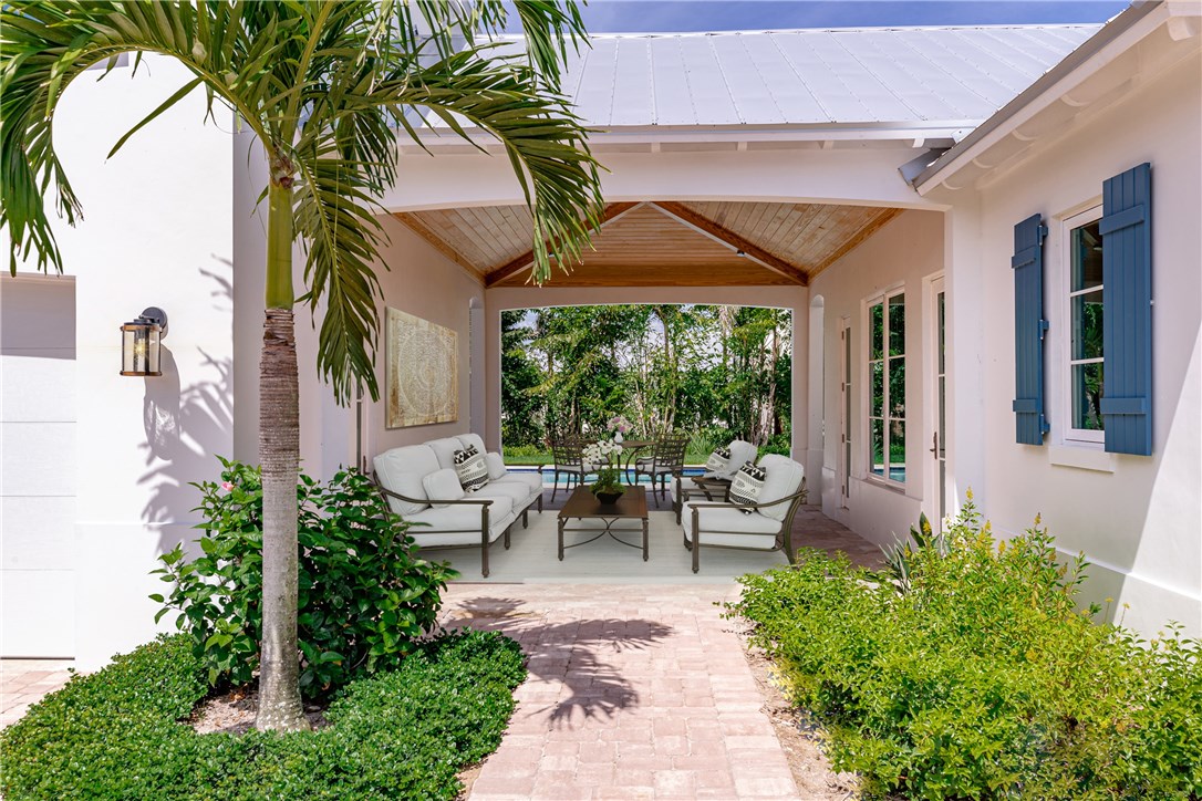 1375 Sandy Lane Vero Beach, FL 32963 - Photo 30 of 36 a view of a patio with couches table and chairs and potted plants