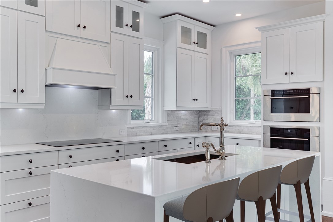 1375 Sandy Lane Vero Beach, FL 32963 - Photo 6 of 36 a kitchen with granite countertop white cabinets and stainless steel appliances