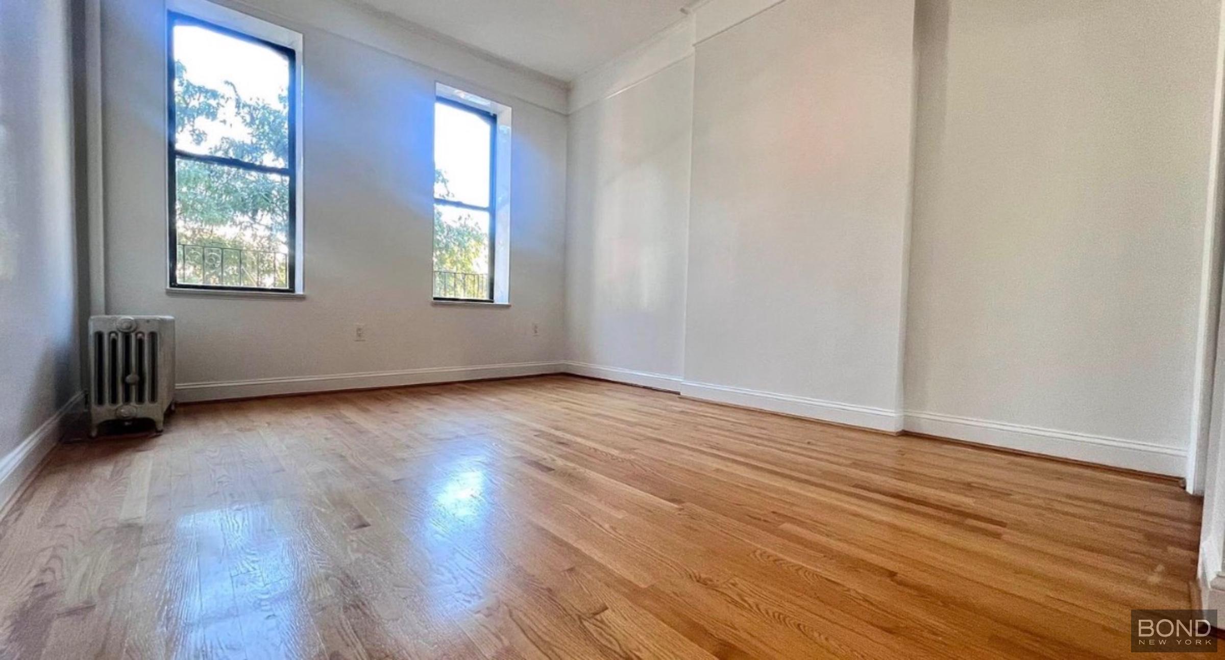 842 Bushwick Avenue, Unit 2R Brooklyn, NY 11221 - Photo 6 of 8 an empty room with wooden floor and windows