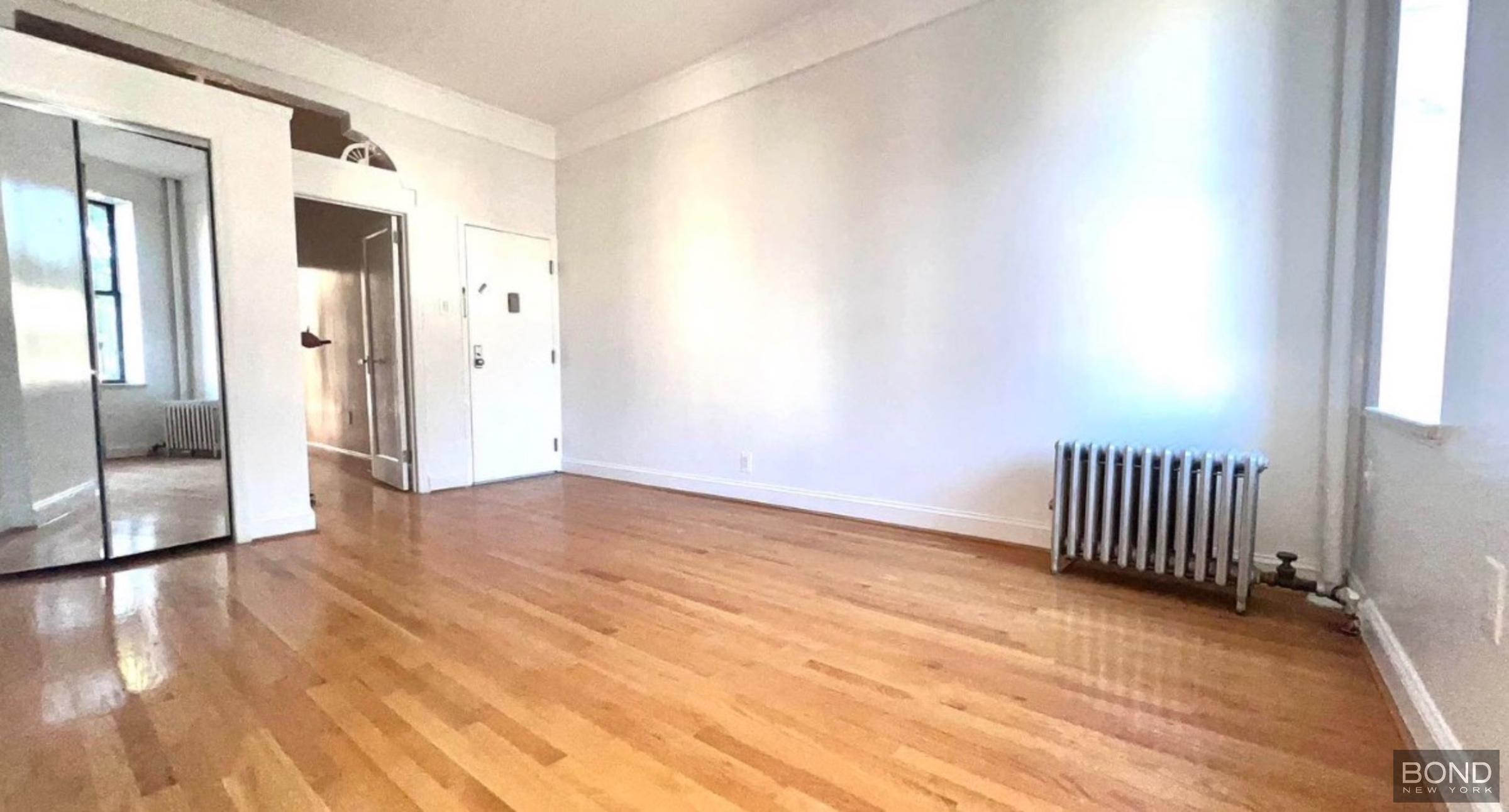 842 Bushwick Avenue, Unit 2R Brooklyn, NY 11221 - Photo 7 of 8 a view of an empty room with wooden floor and a window