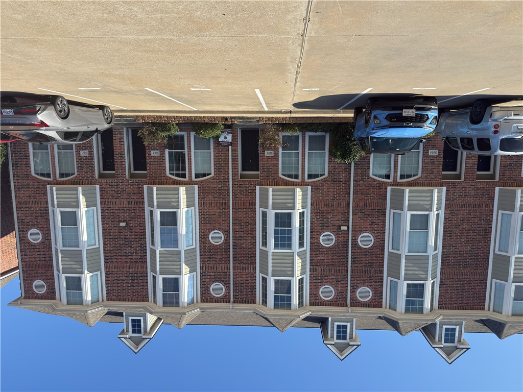 View of apartment building / complex with uncovered parking