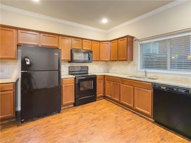 a kitchen with stainless steel appliances granite countertop a refrigerator sink and microwave