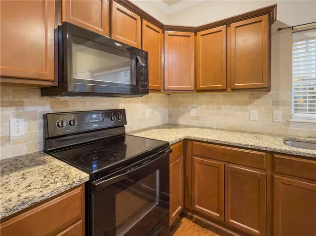 a kitchen with granite countertop cabinets stainless steel appliances and a counter space