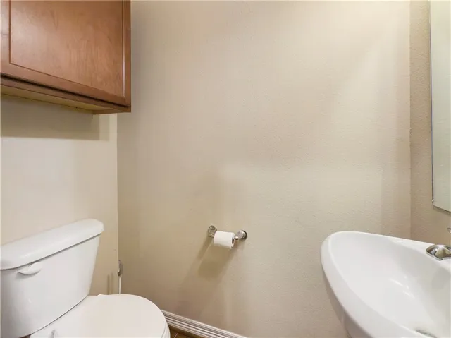 a white toilet sitting next to a white sink and vanity