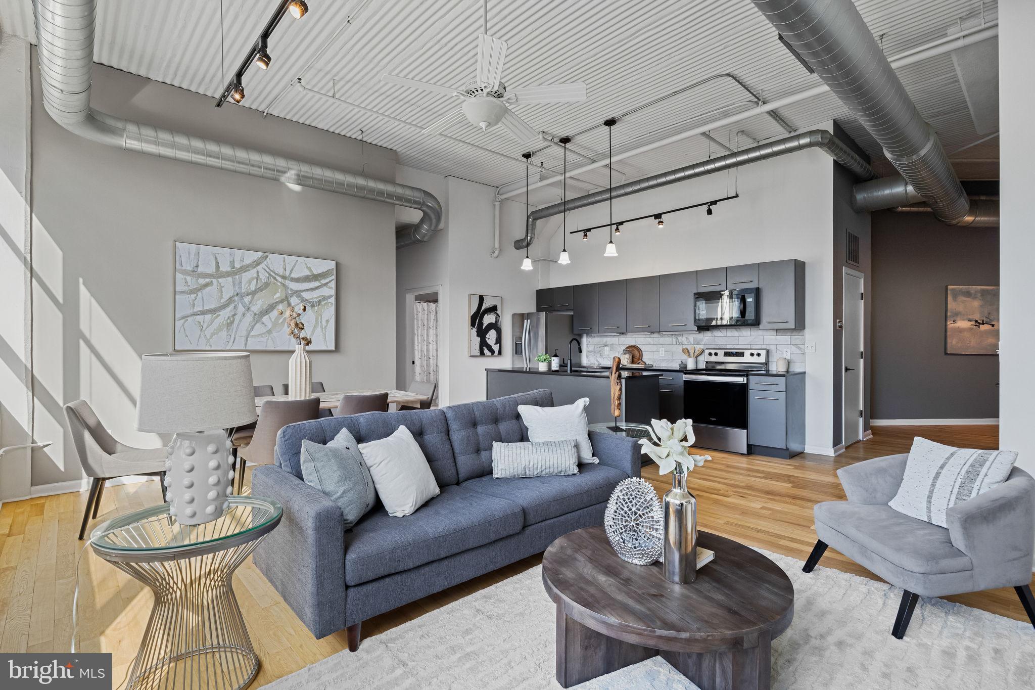 2200-28 Arch Street, Unit 612 Philadelphia, PA 19103 - Photo 12 of 43 a living room with furniture kitchen view and a chandelier