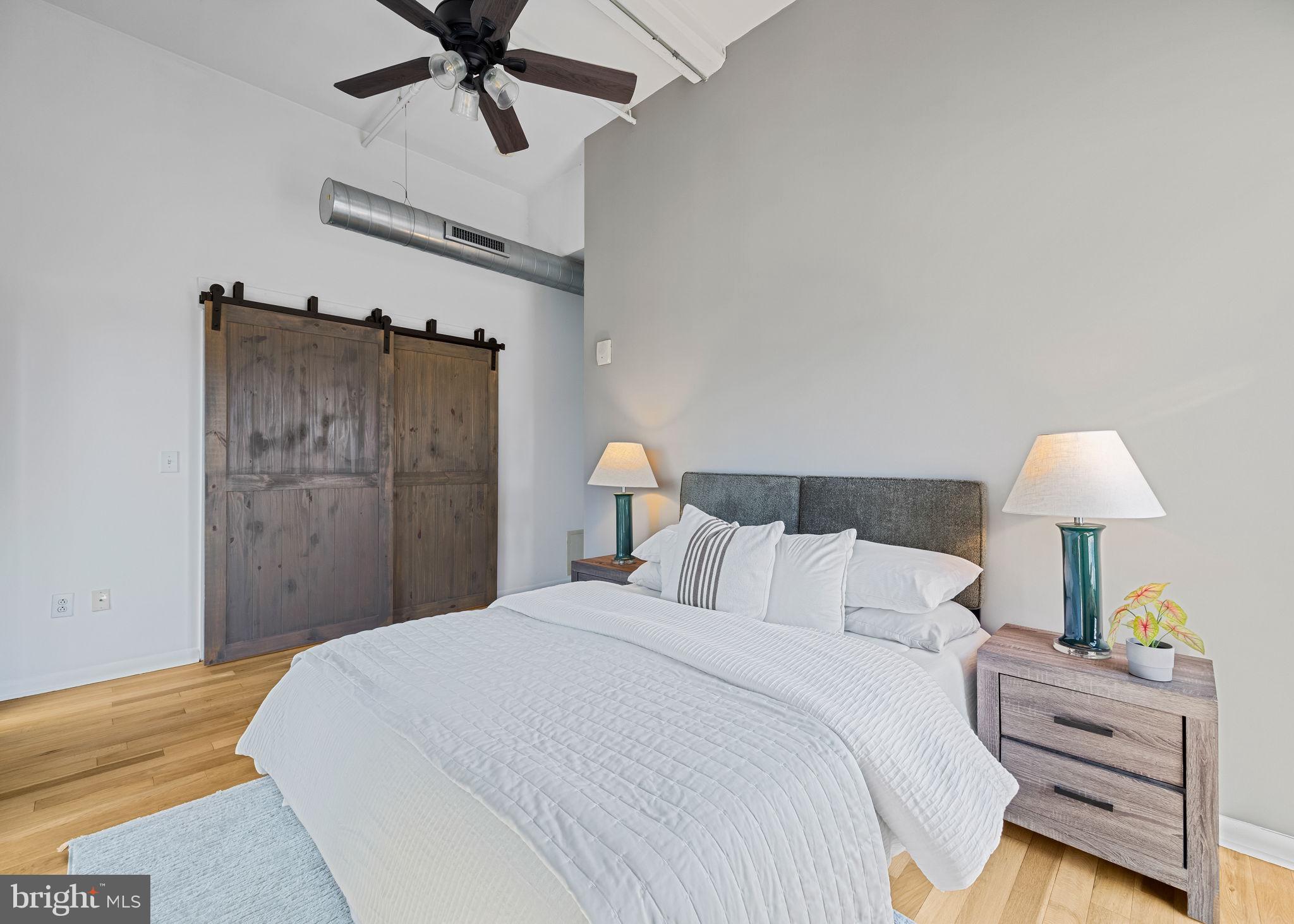 2200-28 Arch Street, Unit 612 Philadelphia, PA 19103 - Photo 34 of 43 a bedroom with a bed and a lamp on the dresser