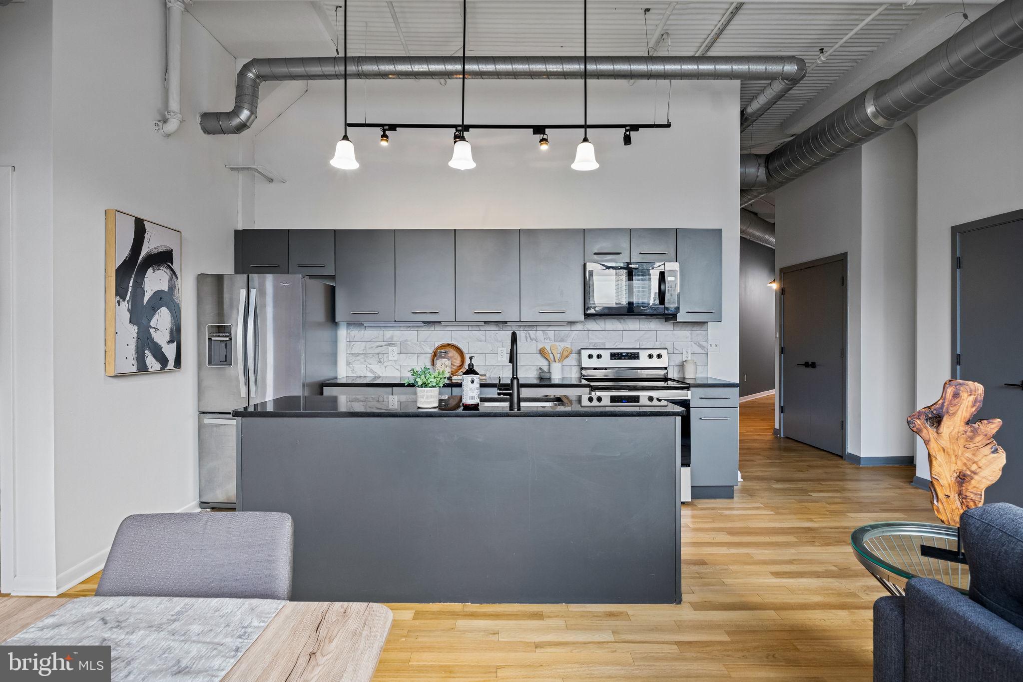 2200-28 Arch Street, Unit 612 Philadelphia, PA 19103 - Photo 8 of 43 a kitchen with stainless steel appliances granite countertop a refrigerator a sink dishwasher a stove and a refrigerator with wooden floor
